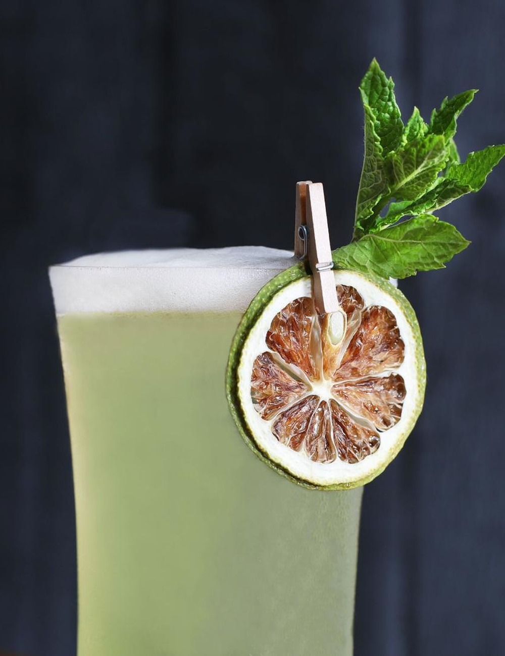 Cocktail garnished with a FRONA dried green lemon slice