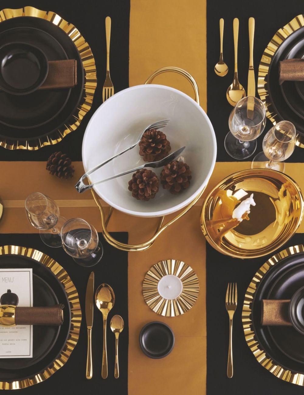 Pince à servir PADERNO Living en inox dans une coupe blanche, sur une table de fête noir et or